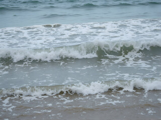Fototapeta premium Waves Crashing Gently on Sandy Beach Shoreline