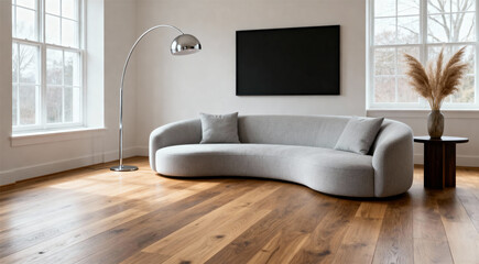 Minimalist living room interior with curved grey sofa arc lamp side table, pampas grass vase natural light windows, empty wall space

