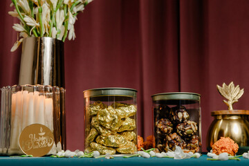Festive Diwali Treats: Jars of sweets, flowers, and a candle create a warm ambiance for the...