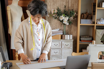  Asian woman designing clothes in her studio.