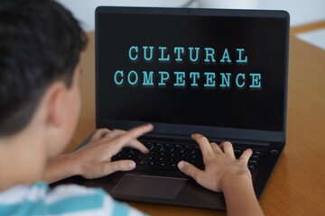 cultural competence concept. adolescent boy typing on his laptop