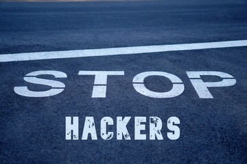 stop hackers. words written on the pavement, on a traffic sign