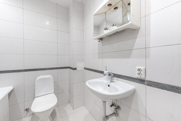 Modern White Bathroom with Sink, Toilet, and Minimalist Decorations