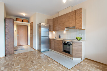 Modern Apartment Kitchen with Wooden Cabinets and Stainless Steel Appliances