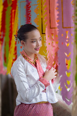 Woman in traditional attire admires colorful paper decorations, creating festive and cultural atmosphere