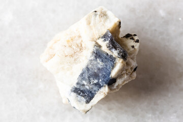 sample of blue corundum sapphire in rock on white