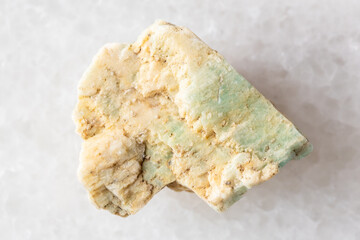 sample of raw amazonite rock on white marble