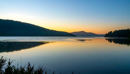Serene lake sunrise reflecting mountains