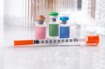 Close up of Vials with Various Injectable Compounds Next to Syringes