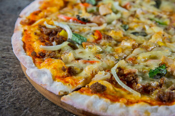 Close Up of Hot Pizza with Cheese and Toppings on Wooden Plate