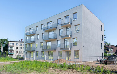 Obraz premium Modern Multi-Family Apartment Building with Sunny Landscaping and Balconies