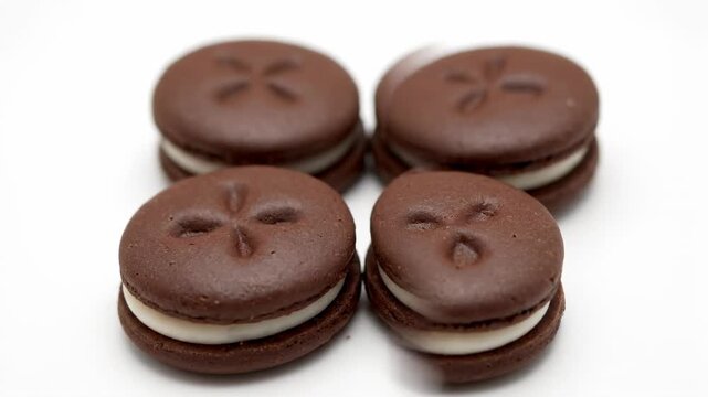 Chocolate Sandwich Cookies XO Pattern - Four delicious chocolate sandwich cookies are arranged in an XO pattern on a white background. The cookies have a distinctive design imprinted on top.