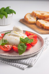 Traditional Italian burrata cheese with salad of delicious cherry tomato, basil leaves and olive oil.