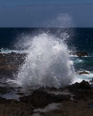 Gran Canaria, north west coast around natural swimming pools Salinas de Agaete, waves breaking against old eroded dark lava platform