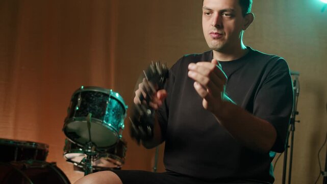 Musical instrument, tambourine Percussion, man playing in studio, sound and creativity. Plastic tambourine in a mans hand.