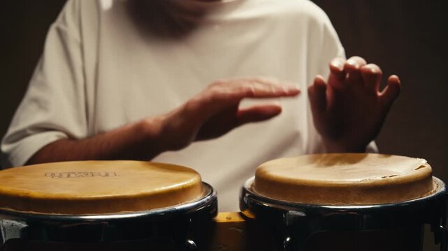 Bongo drummer percussionist performing on a stage with conga drums set kit during jazz rock show performance, tumbadora quinto with latin cuban afro-cuban jazz band performing in the background