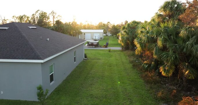 Lawn mowing on Florida property backyard. Man worker riding zero turn tractor cutting grass at suburban home.