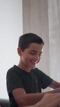 cute boy excitedly shows his handwritten work to friend who smiles while glancing at his paper and playfully slaps his head making him shake his head with mock frustration