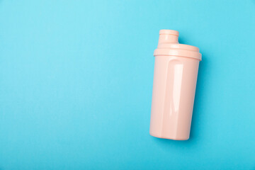 Protein shake with protein powder on a colored background. The powder is mixed with water or milk. A dietary supplement for a balanced diet. Whey protein. Fitness and gym diet nutrition.