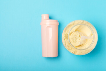 Protein shake with protein powder on a colored background. The powder is mixed with water or milk. A dietary supplement for a balanced diet. Whey protein. Fitness and gym diet nutrition.