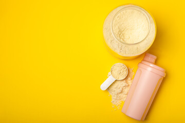 Protein shake with protein powder on a colored background. The powder is mixed with water or milk. A dietary supplement for a balanced diet. Whey protein. Fitness and gym diet nutrition.