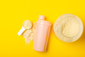 Protein shake with protein powder on a colored background. The powder is mixed with water or milk. A dietary supplement for a balanced diet. Whey protein. Fitness and gym diet nutrition.