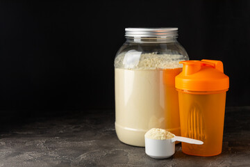 Protein shake with protein powder on a colored background. The powder is mixed with water or milk. A dietary supplement for a balanced diet. Whey protein. Fitness and gym diet nutrition.