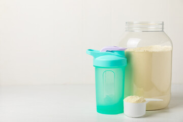 Protein shake with protein powder on a colored background. The powder is mixed with water or milk. A dietary supplement for a balanced diet. Whey protein. Fitness and gym diet nutrition.