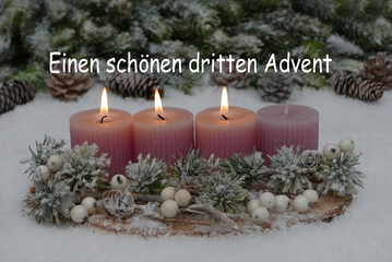 Adventsdekoration mit Tannenzweigen, Zapfen und rosa Kerzen im Schnee, drei davon brennen zum dritten Advent.	Einen schönen dritten Advent.