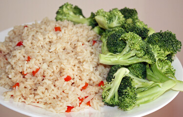 Cooked wholegrain brown rice with diced red peppers and a side of fresh organic chopped broccoli