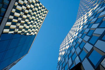 Glass reflections of Stockholm office tower under blue sky, modern Scandinavian architecture expressing geometry, perspective and contemporary design for creative visual compositions