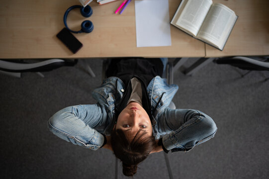 Tired student in library - Powered by Adobe