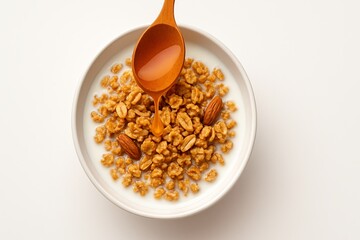 A wooden spoon pours honey onto a bowl of crunchy cereal with almonds and milk