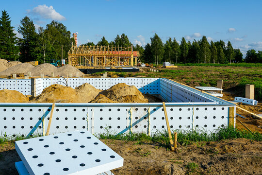 ICF foundation system with soil piles and wooden frame structure at construction site