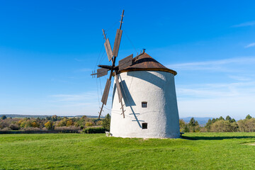 Rustic stone windmill in a grassy field
