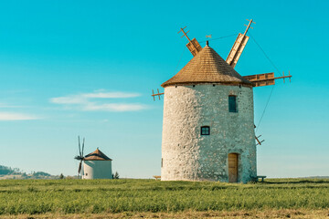 Rustic stone windmill in a grassy field