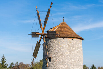 Rustic stone windmill in a grassy field