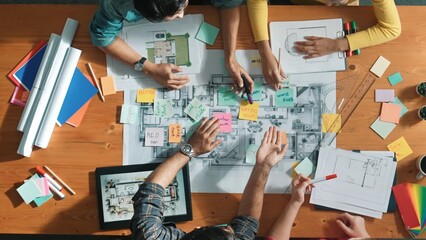 Top view of civil engineer discussing about house construction while planning about building design at meeting table with blueprint and architectural equipment. Design brainstorming idea.Symposium.