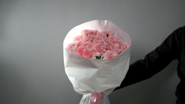 Bouquet of pink carnations on a gray background. Florist assembly a bouquet to order