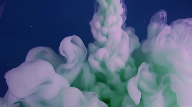 Abstract pastel mint green and lavender ink swirling in dark liquid