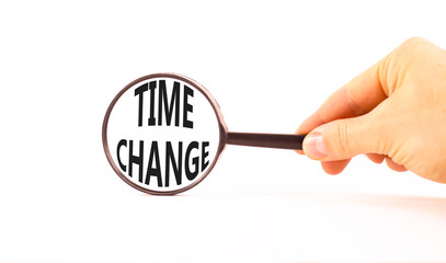 Time change symbol. Concept word Time change on beautiful magnifying glass. Businessman's hand. Beautiful white paper background. Black magnifying glass. Business time change concept. Copy space.