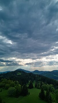 Vertical Hyperlapse of Lush Green Hills with Sun Rays and Moving Clouds in Spring