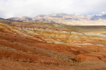 Red sandy mountains in Altai, reminiscent of Martian landscapes. The terrain has various shades of red and orange, with dry rocky surfaces.