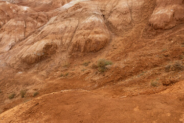 Red sandy mountains in Altai, reminiscent of Martian landscapes. The terrain has various shades of red and orange, with dry rocky surfaces.