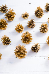 golden pine cones Christmas decoration on white wood table background
