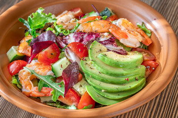 Fresh prawn avocado salad cherry tomatoes wooden table citrus dressing