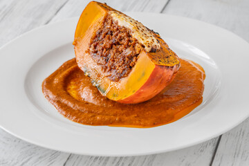 Portion of baked Hokkaido pumpkin with beef, tomato sauce, mozzarella cheese