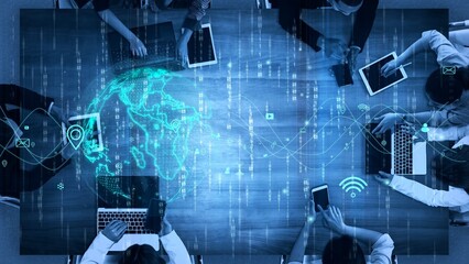 Dynamic business meeting showcasing a diverse team engaging with technology, collaborating on data analysis, and utilizing digital tools over a wooden table. Xenic