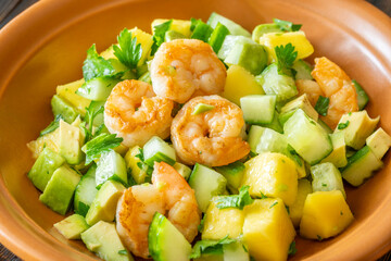 Fresh shrimp salad with mango, avocado, cucumber in lemon olive dressing