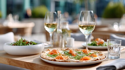 Enjoy a delicious prosciutto and mozzarella pizza paired with a refreshing salad and a glass of wine at an outdoor setting.